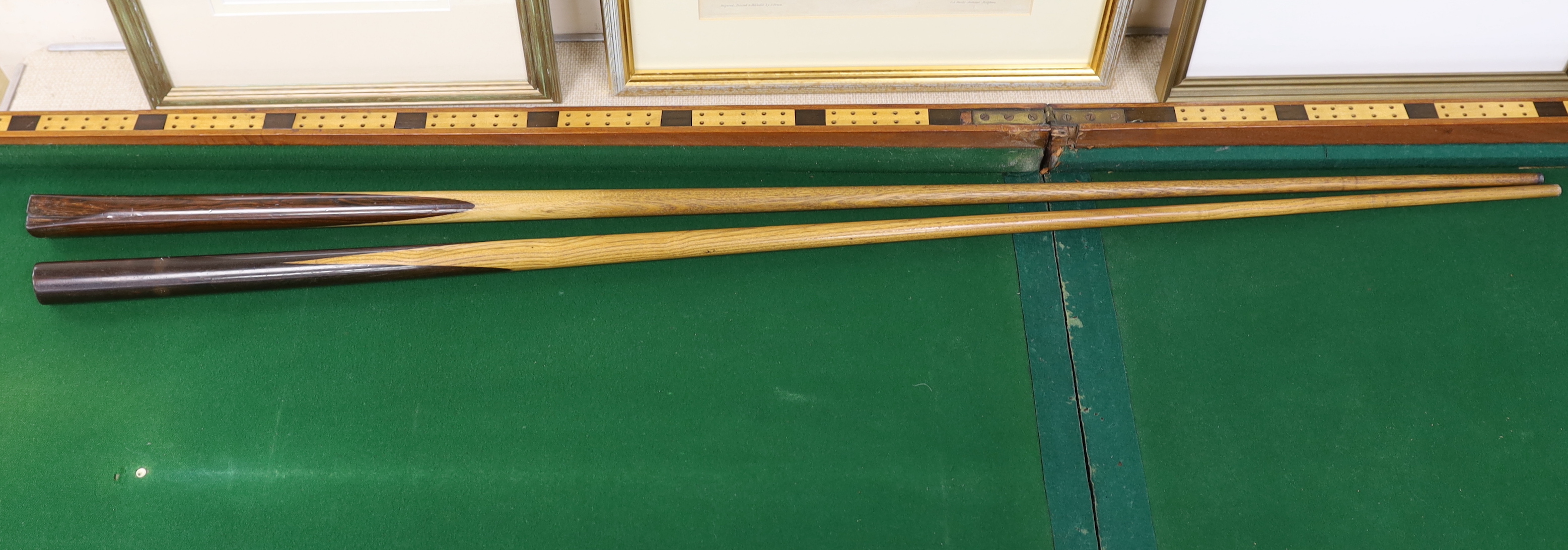 A Victorian folding cased bagatelle board, green baize interior with markers and two cues, 223.5cm open